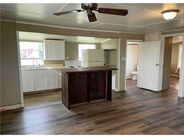a kitchen with stainless steel appliances granite countertop a sink and wooden floor