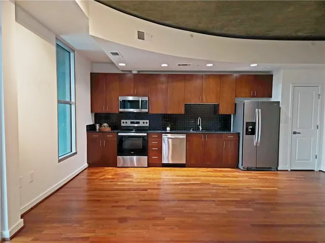 a kitchen with stainless steel appliances wooden cabinets and a refrigerator