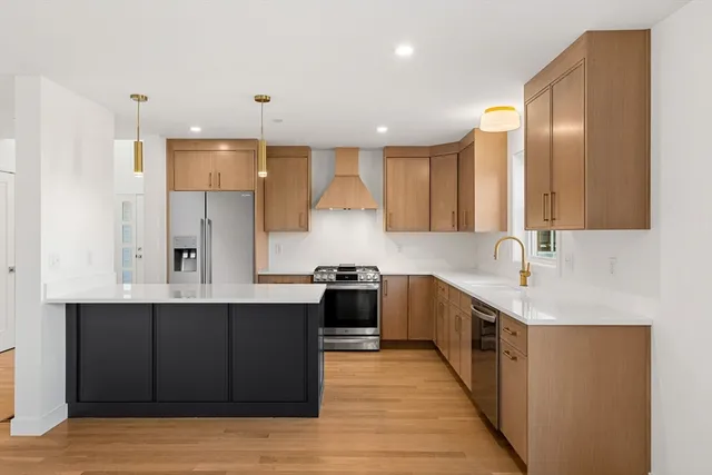 a kitchen with stainless steel appliances granite countertop a sink stove and refrigerator