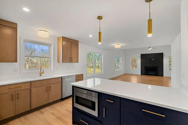 a kitchen with stainless steel appliances a sink and wooden floor