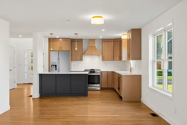 a kitchen with stainless steel appliances granite countertop a stove a sink and a refrigerator