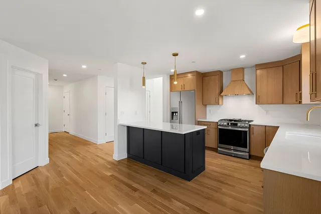 a kitchen with stainless steel appliances granite countertop a stove a sink and a refrigerator