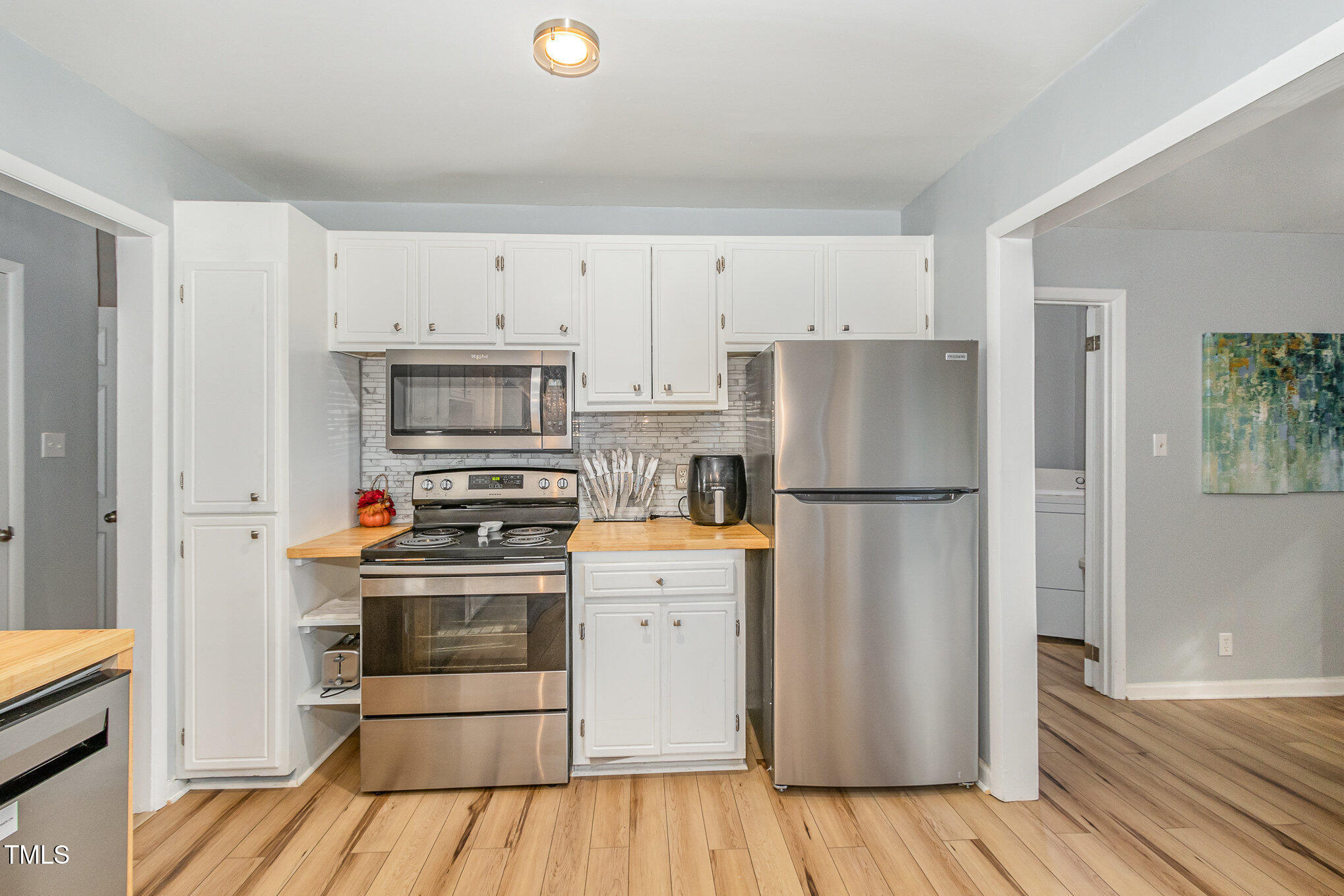 427 Ridgefield Road Chapel Hill, NC 27517 - Photo 11 of 27 a kitchen with a refrigerator stainless steel appliances wooden floor and cabinets
