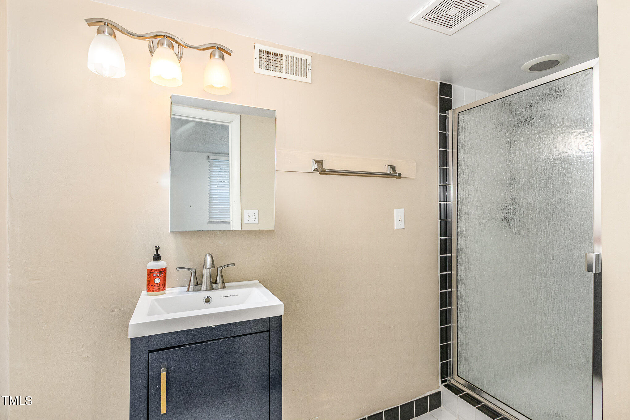 427 Ridgefield Road Chapel Hill, NC 27517 - Photo 17 of 27 a bathroom with a sink a mirror and shower