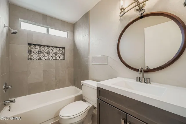 a bathroom with a sink a mirror a toilet and a bathtub