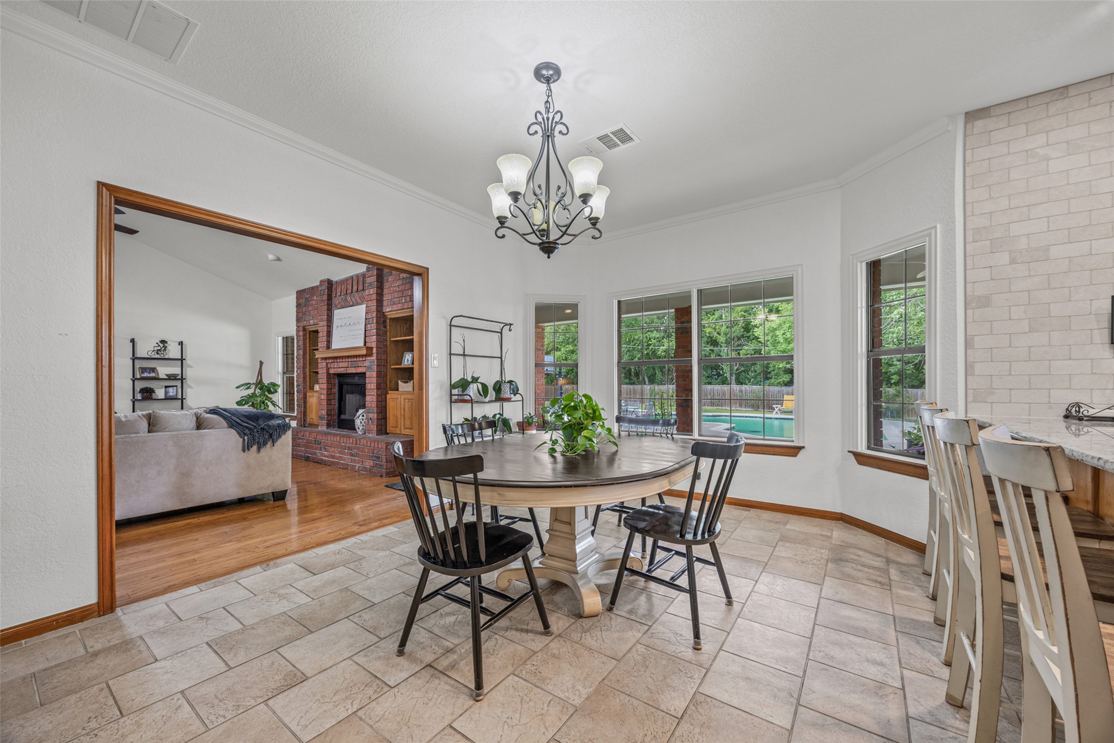 2000 Spinel Road Pflugerville, TX 78660 - Photo 7 of 31 A casual dining area connects seamlessly to a bright living space, with serene views of the outdoor pool.