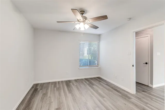 an empty room with fan and windows