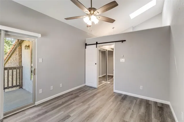 a view of a hallway with closet and wooden floor