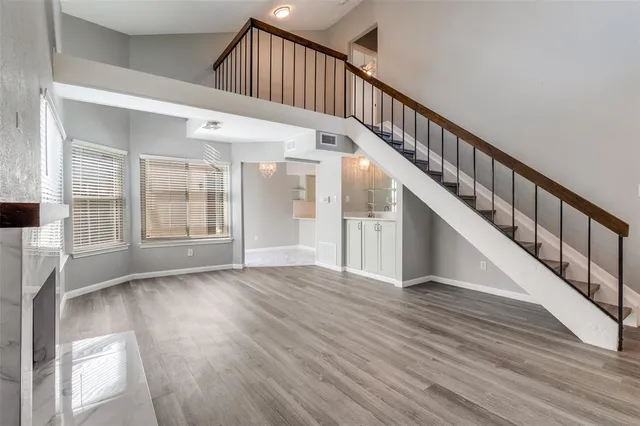 a view of staircase with wooden floor and white walls