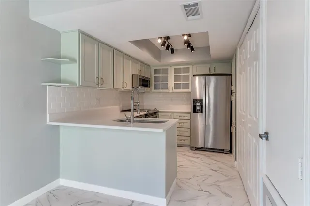 a kitchen with stainless steel appliances granite countertop a sink and a refrigerator