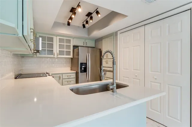 a kitchen with stainless steel appliances granite countertop a sink refrigerator and microwave