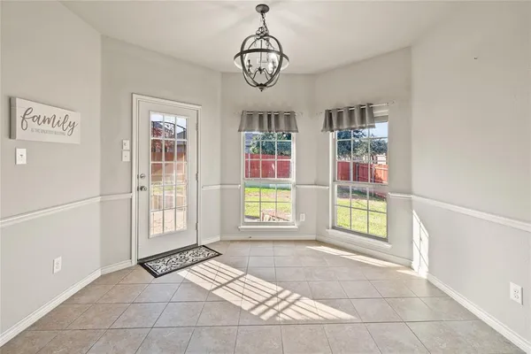 a spacious bedroom with a bed and a chandelier