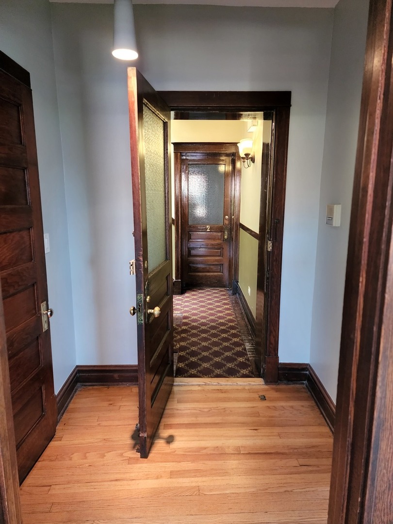 5225 North Clark Street, Unit 2 Chicago, IL 60640 - Photo 14 of 21 a view of a hallway with wooden floor and staircase