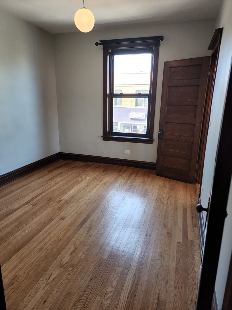 5225 North Clark Street, Unit 2 Chicago, IL 60640 - Photo 16 of 21 an empty room with wooden floor and windows