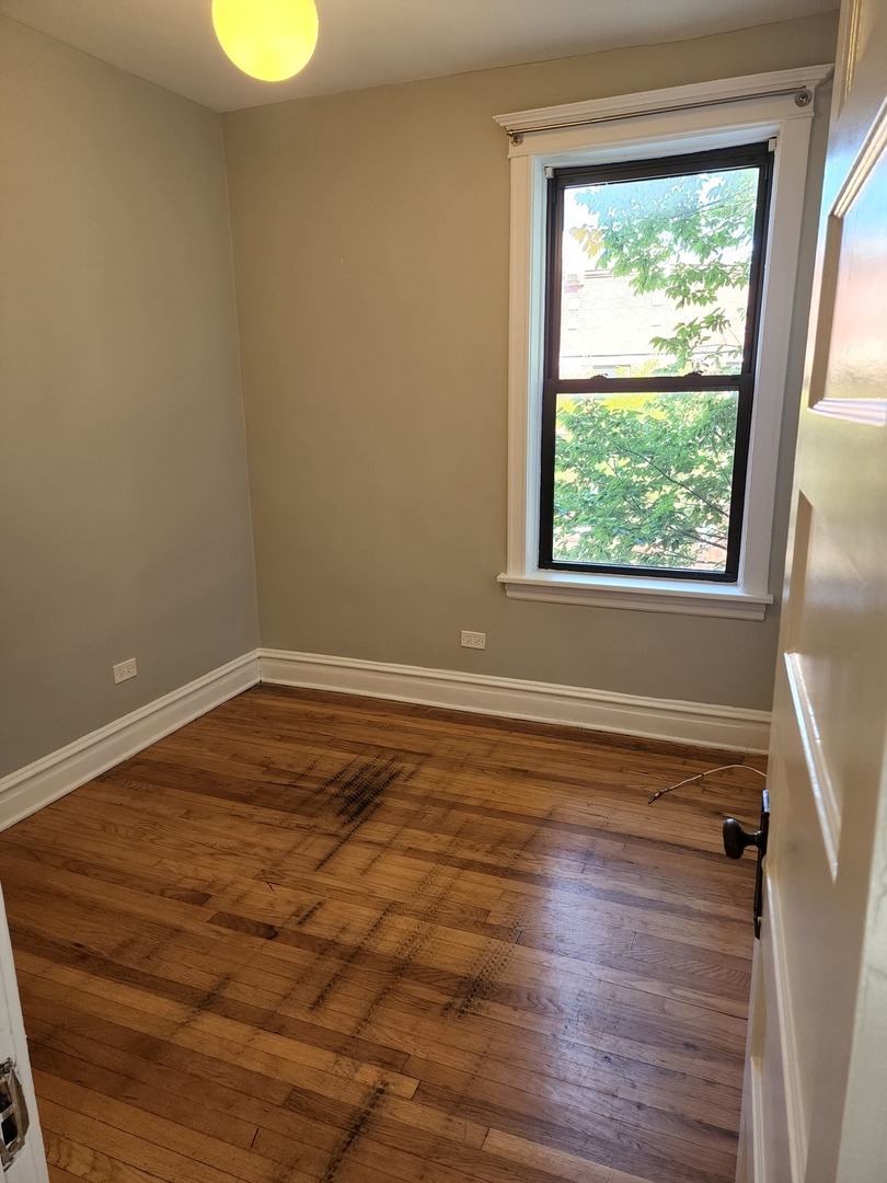 5225 North Clark Street, Unit 2 Chicago, IL 60640 - Photo 17 of 21 a view of empty room with wooden floor and fan