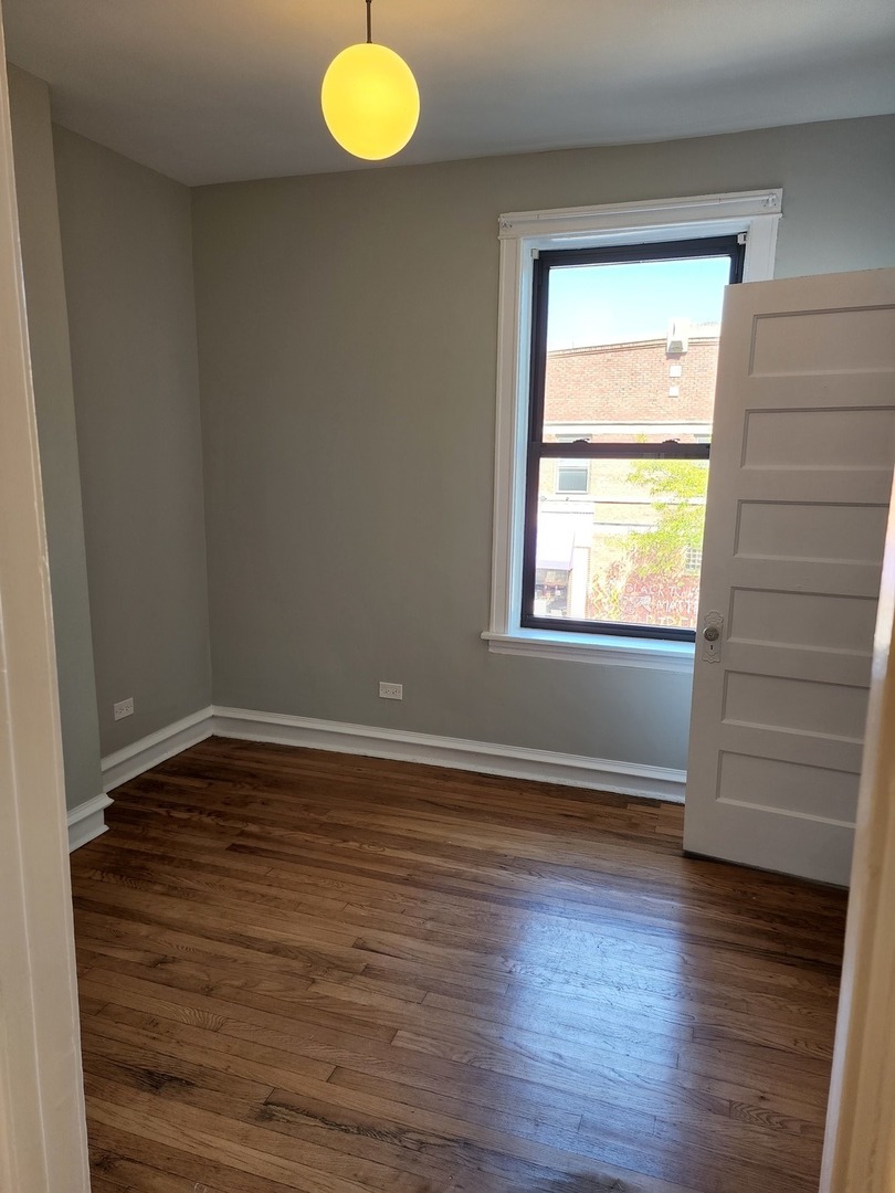 5225 North Clark Street, Unit 2 Chicago, IL 60640 - Photo 19 of 21 a view of an empty room with wooden floor and a window