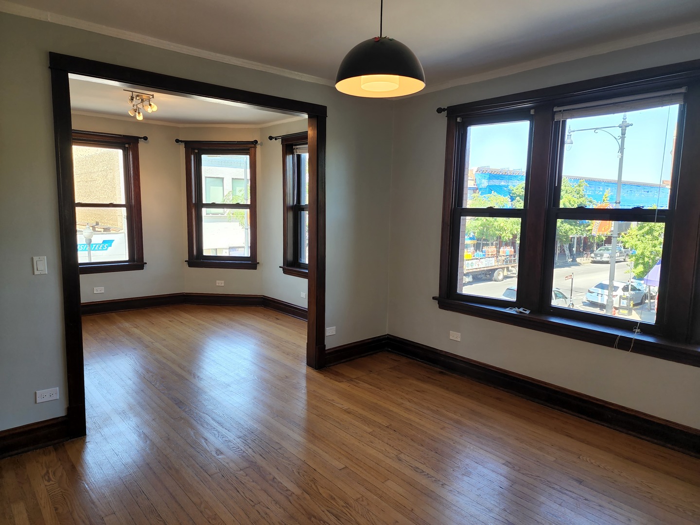 5225 North Clark Street, Unit 2 Chicago, IL 60640 - Photo 2 of 21 an empty room with wooden floor and windows