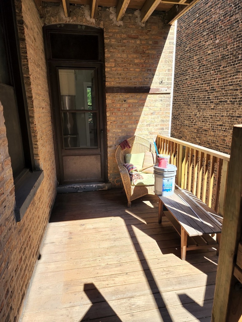 5225 North Clark Street, Unit 2 Chicago, IL 60640 - Photo 21 of 21 a view of balcony with wooden floor and outdoor seating