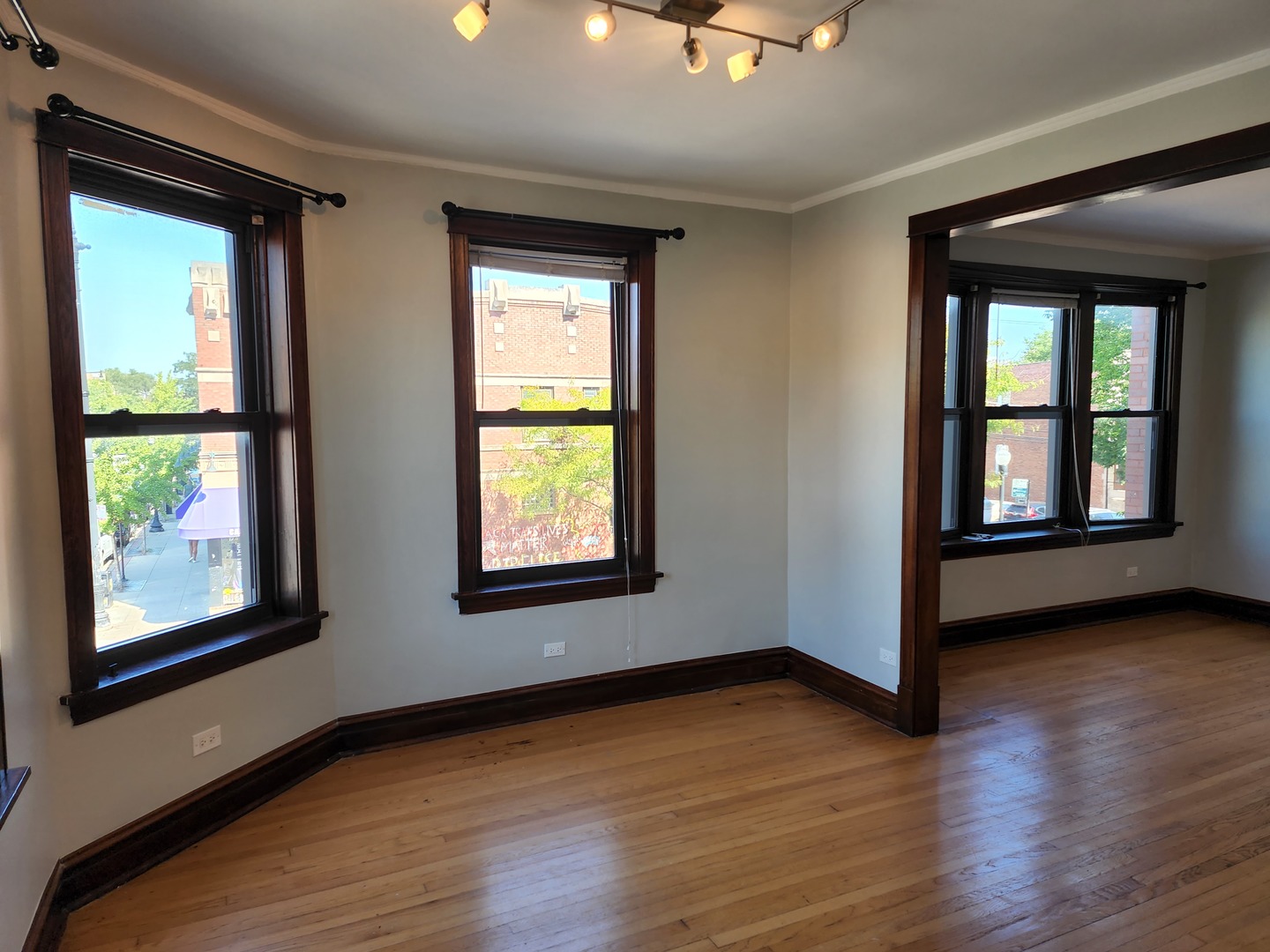 5225 North Clark Street, Unit 2 Chicago, IL 60640 - Photo 3 of 21 an empty room with wooden floor and windows