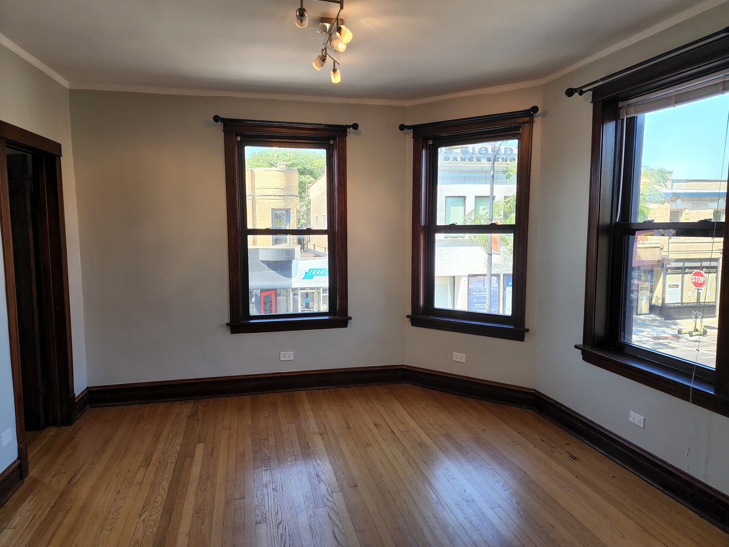 5225 North Clark Street, Unit 2 Chicago, IL 60640 - Photo 4 of 21 an empty room with wooden floor and windows