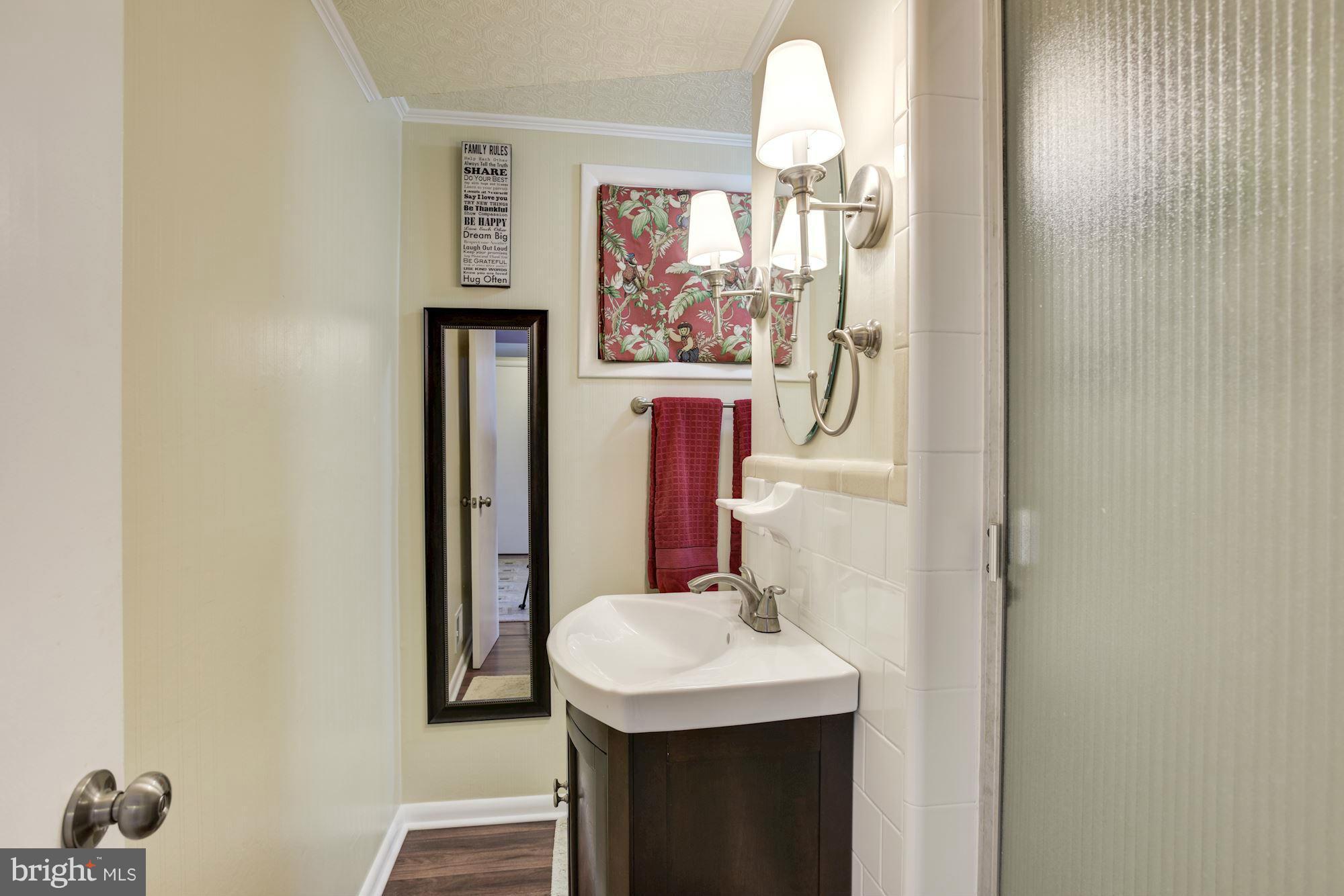 6705 Maxalea Road Baltimore, MD 21239 - Photo 19 of 30 a bathroom with a sink a mirror and window