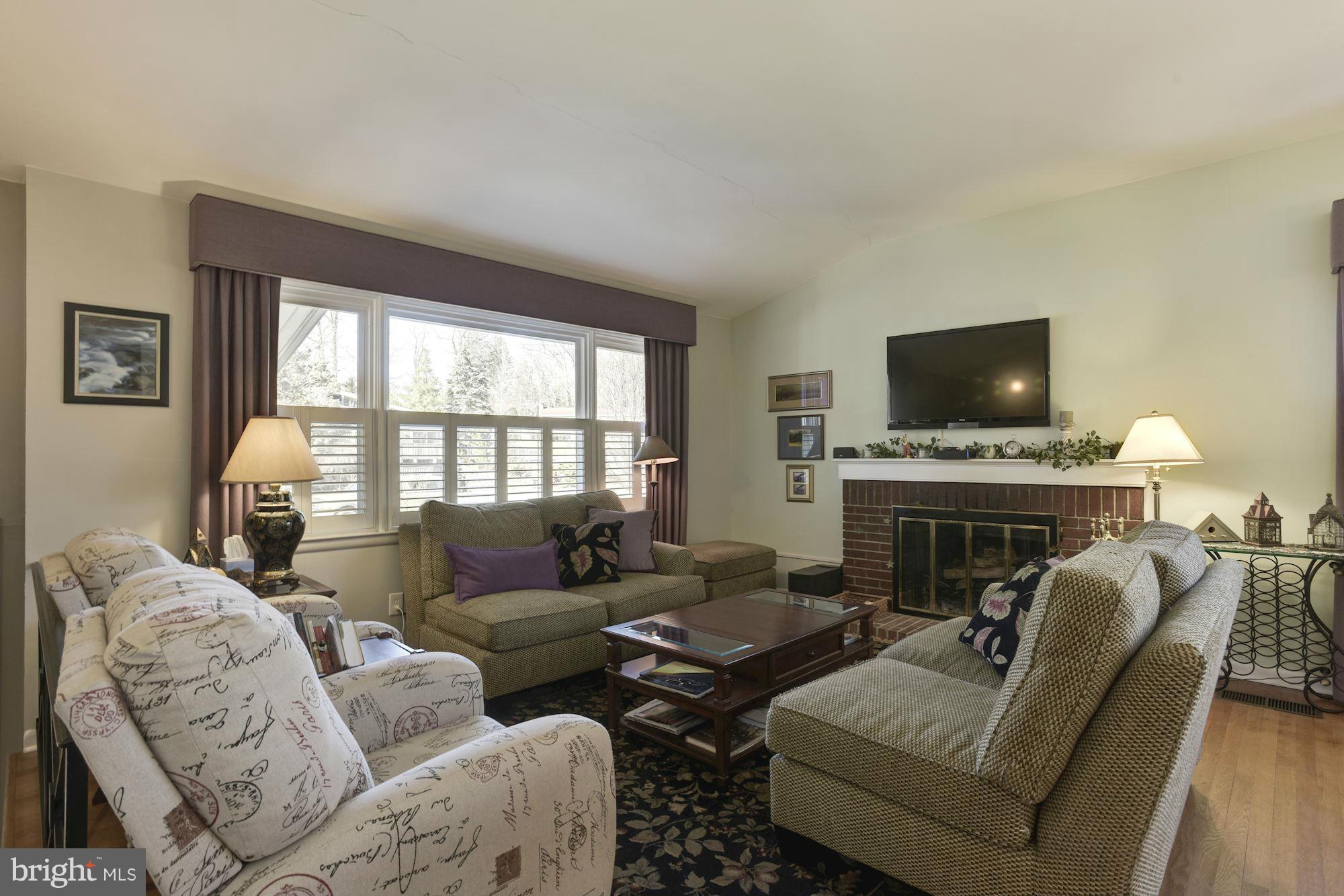 6705 Maxalea Road Baltimore, MD 21239 - Photo 4 of 30 a living room with furniture a fireplace and a flat screen tv