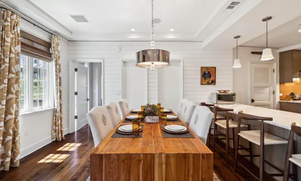 a kitchen with stainless steel appliances kitchen island granite countertop a dining table chairs and a refrigerator