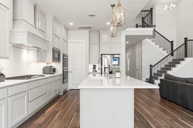 a living room with furniture a fireplace and a chandelier