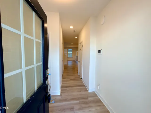 a view of a hallway with wooden floor and staircase