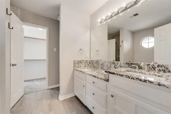 a bathroom with a granite countertop sink and a mirror