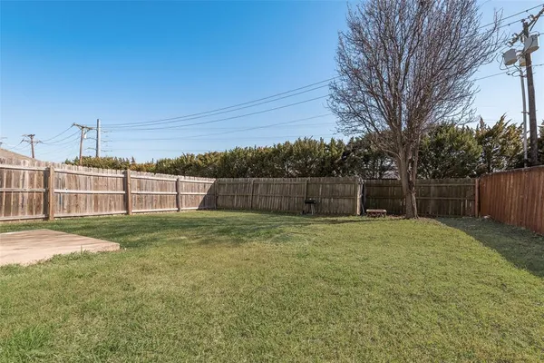 a backyard of a house with plants and large trees