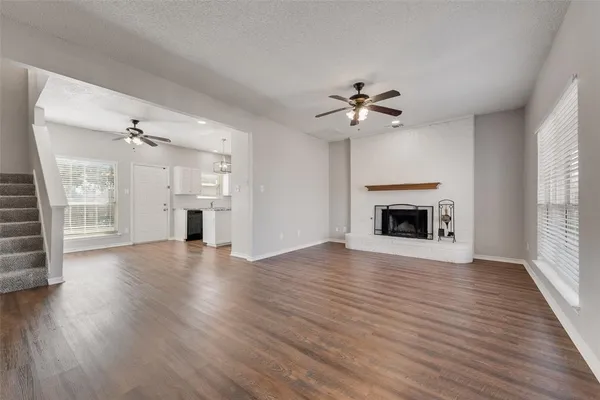 a view of an empty room with a fireplace and a window