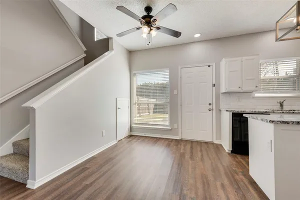 a view of a kitchen with a fridge wooden floor and a window