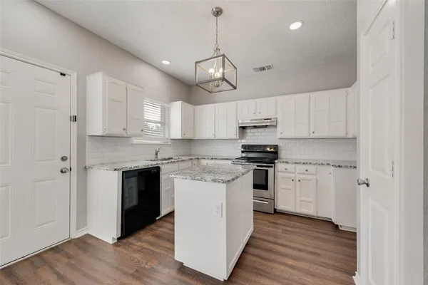 a kitchen with stainless steel appliances granite countertop a stove a sink and a refrigerator