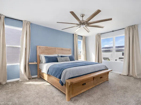 a bed room with a bed and a ceiling fan