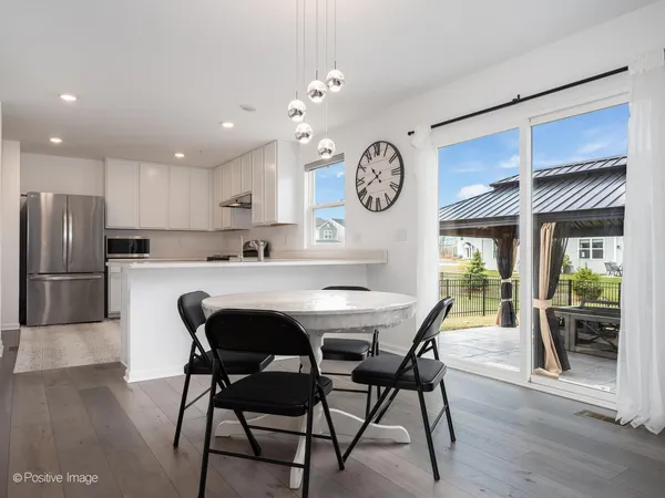 a kitchen with stainless steel appliances granite countertop a table chairs a sink and dishwasher