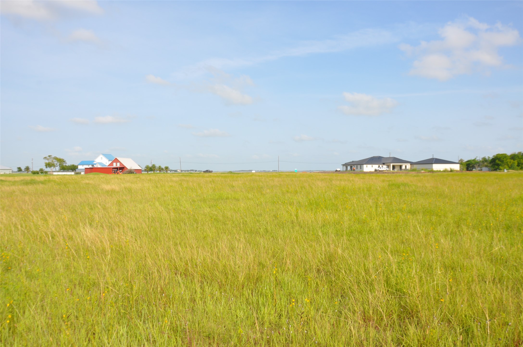305 Bayshore Road Palacios, TX 77465 - Photo 25 of 25 A vast, verdant expanse offers idyllic country living, framed by distant homes under an open sky.