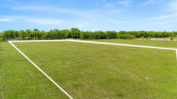 a view of a green field with wooden fence