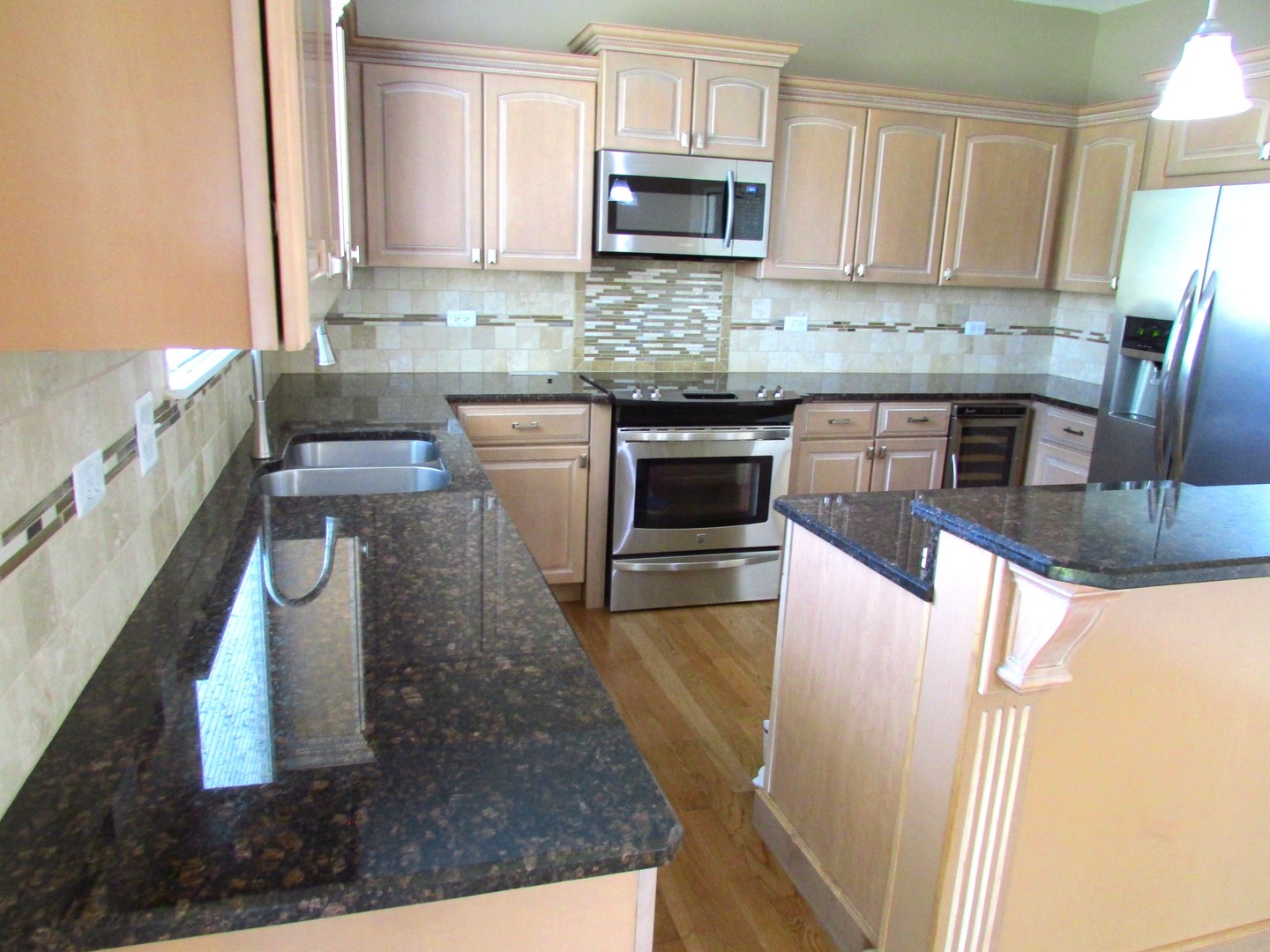 10123 Ashley Street Huntley, IL 60142 - Photo 3 of 33 a kitchen with stainless steel appliances granite countertop a sink a stove top oven a counter space and cabinets