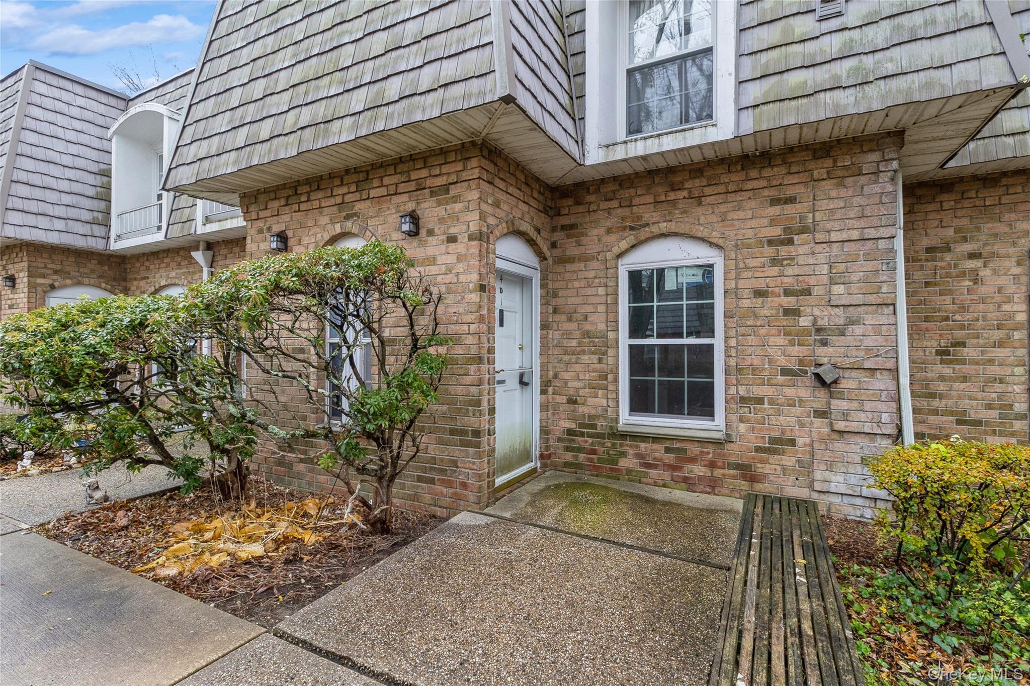 Entrance to property with mansard roof and brick siding