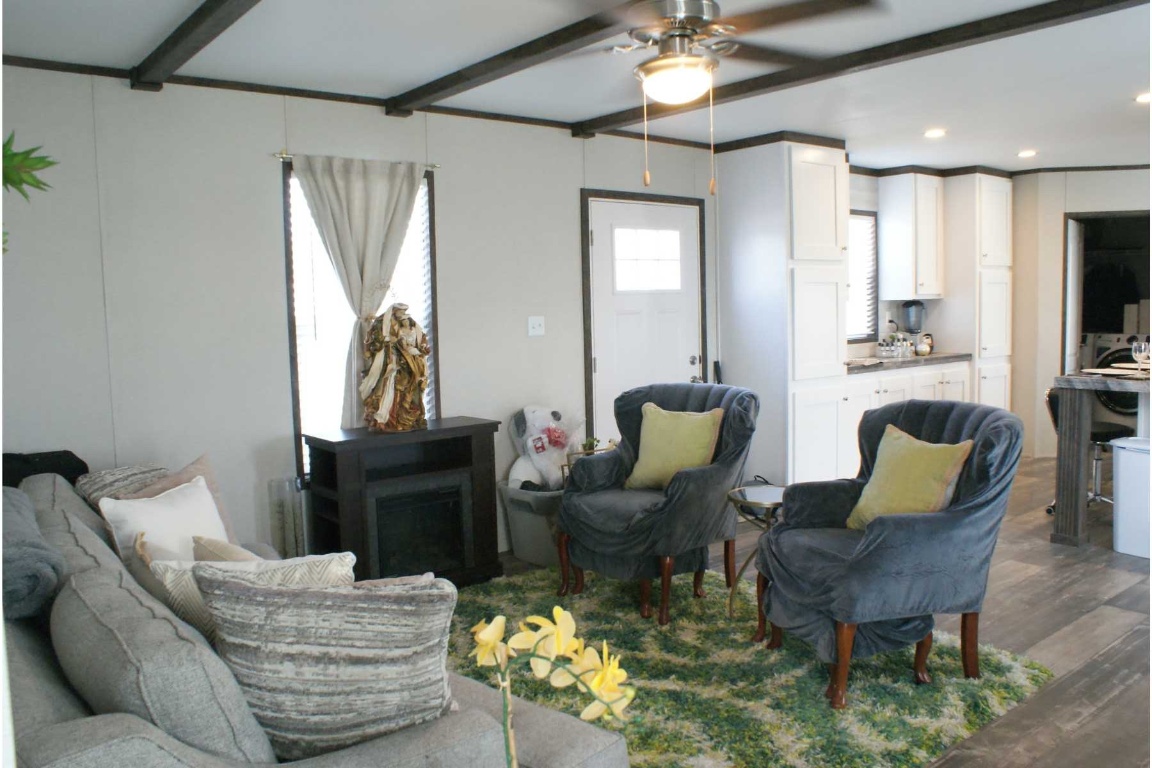 501 Mesquite Road San Marcos, TX 78666 - Photo 2 of 33 Living area featuring dark wood finished floors, ceiling fan, a fireplace, recessed lighting, and beamed ceiling