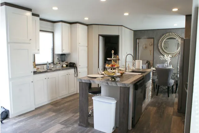 a kitchen with a sink a stove cabinets and living room view