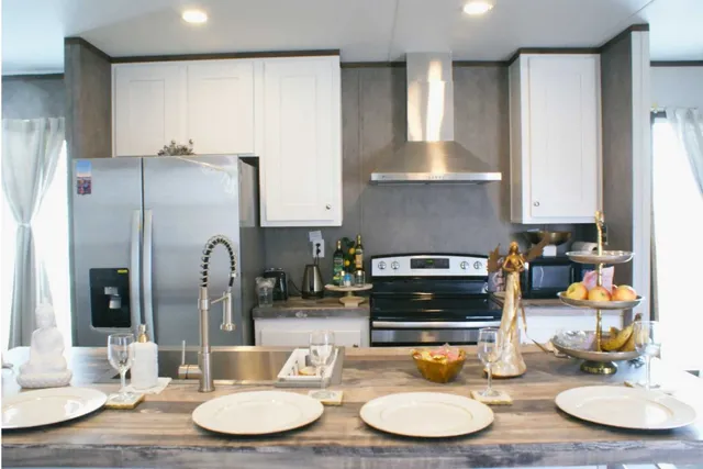 a kitchen with stainless steel appliances granite countertop a refrigerator and a dining table