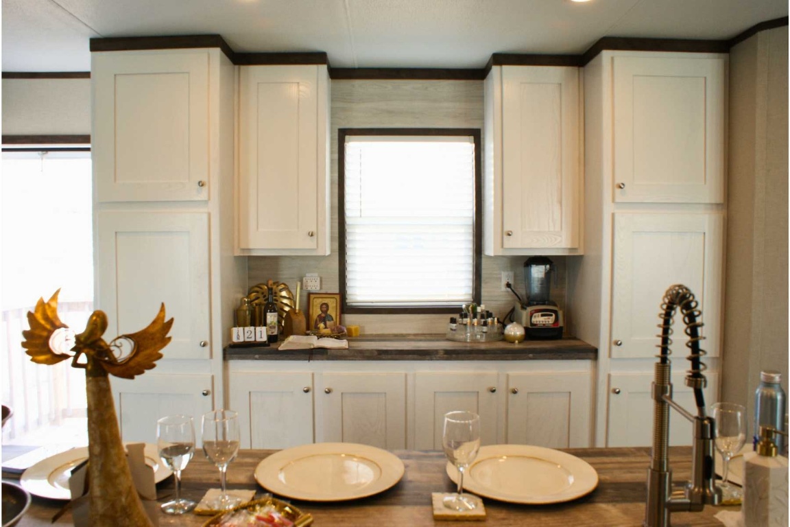501 Mesquite Road San Marcos, TX 78666 - Photo 7 of 33 Kitchen with dark countertops and white cabinetry