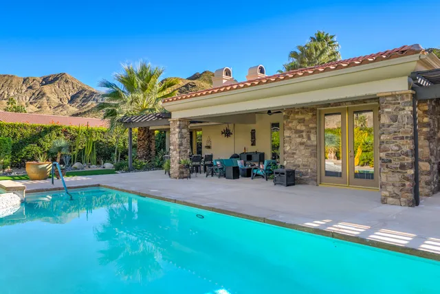 a view of a patio with table and chairs potted plants and palm tree