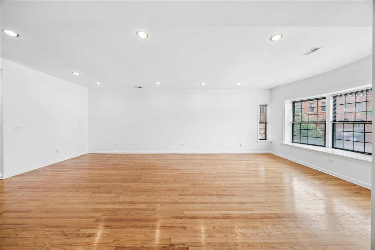 2363 East 70th Street, Unit 1 Chicago, IL 60649 - Photo 7 of 26 a view of an empty room with wooden floor and a window