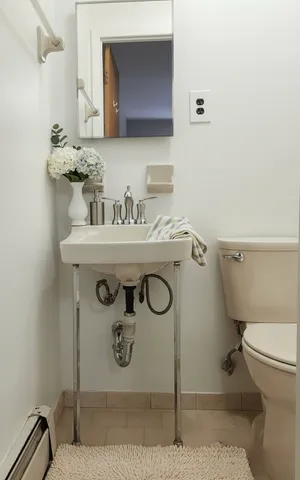 a bathroom with a toilet a sink and mirror