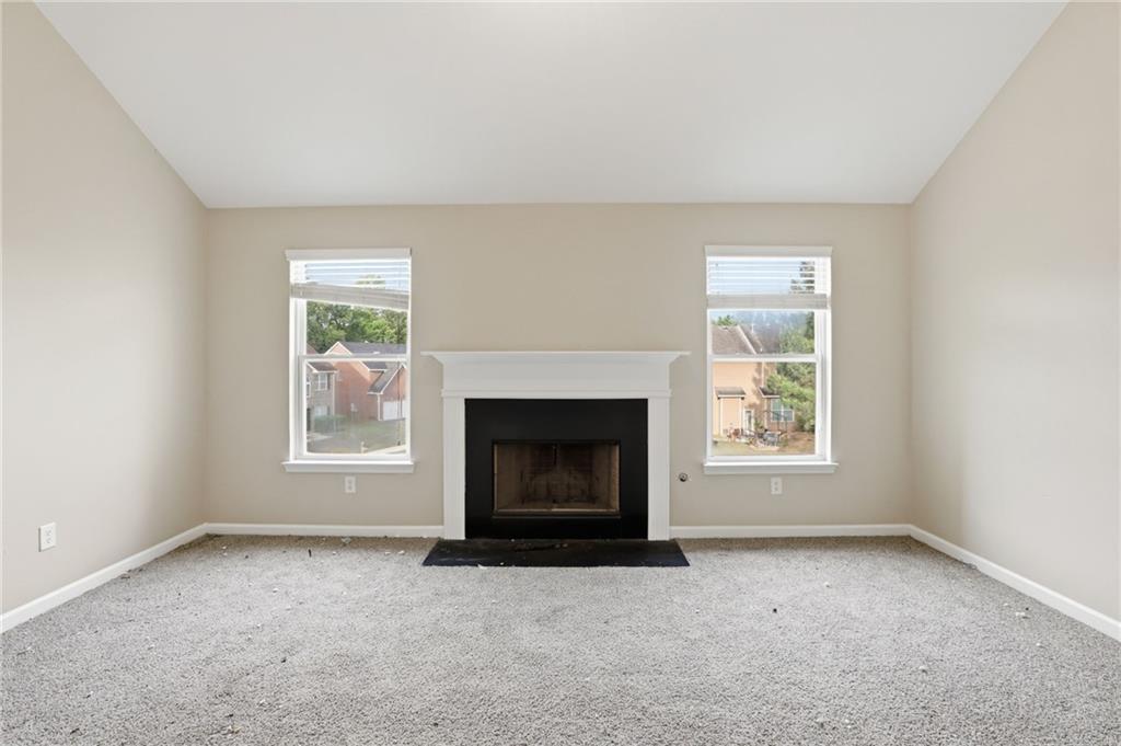4968 Locherby Drive Fairburn, GA 30213 - Photo 11 of 39 an empty room with windows and fireplace