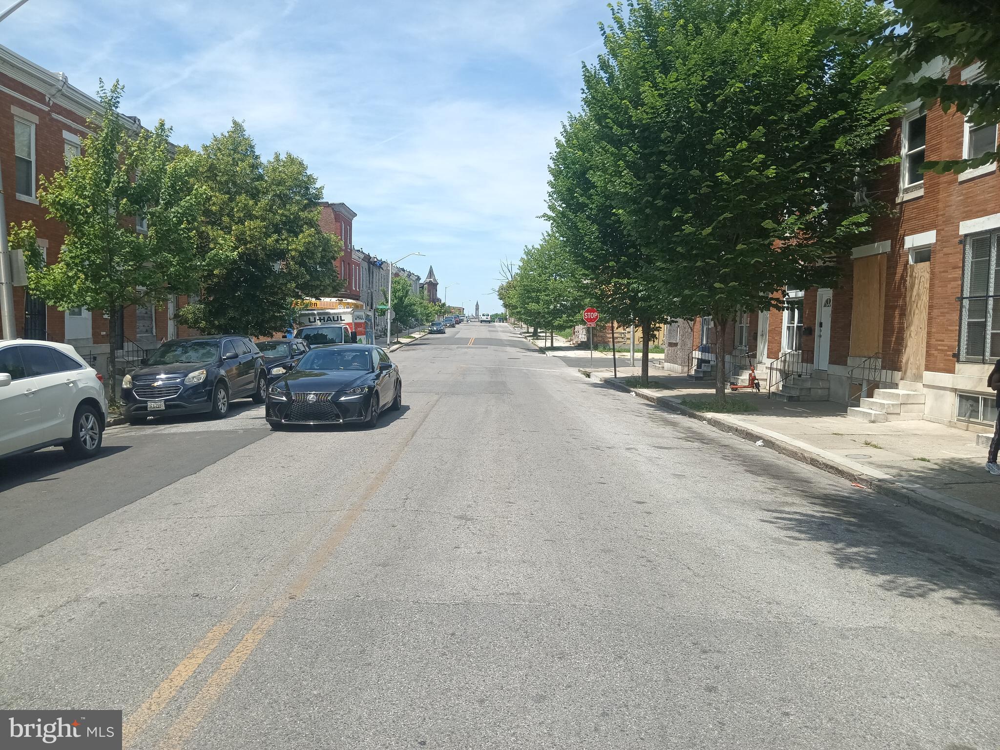 2414 East Oliver Street Baltimore, MD 21213 - Photo 9 of 9 a view of road with card parked on side and retail shops