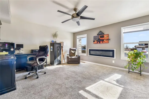 a view of a workspace with furniture and a ceiling fan